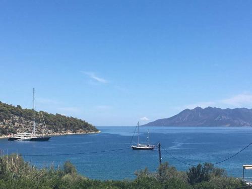two boats are docked in a large body of water at Poseidon in Ancient Epidavros
