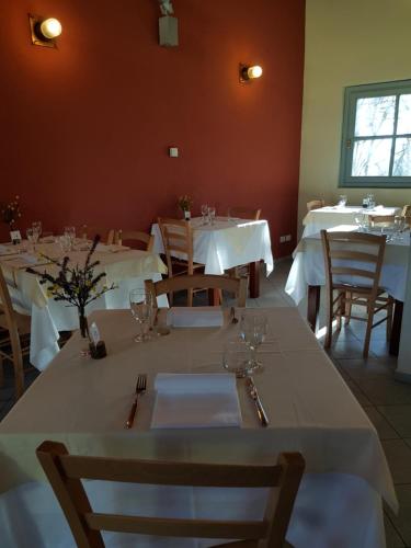 a dining room with tables and chairs with white tablecloths at Certosa 1515 in Avigliana