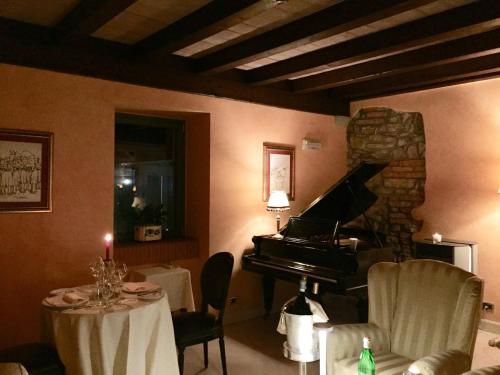 a room with a piano and a table with a candle at Relais La Colombara Spa & Wellness in Travo
