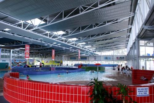 a large indoor swimming pool with people in it at Townhouse Hotel in Wagga Wagga