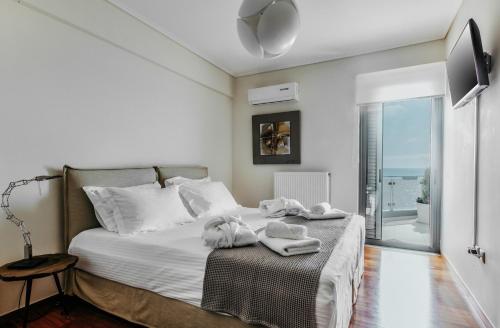 1 dormitorio con 1 cama con toallas en DN Sea Apartments, en Kalamata