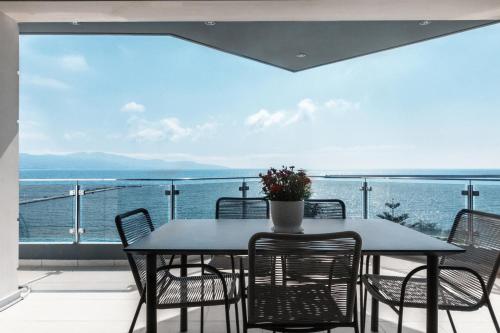 a table and chairs on a balcony with a view of the ocean at DN Sea Apartments in Kalamata