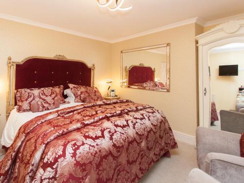 a bedroom with a large bed and a mirror at The Somerville in Torquay