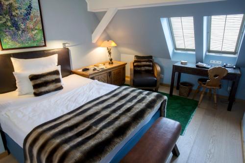a bedroom with a bed and a desk and a chair at Schlosshotel Hugenpoet in Essen