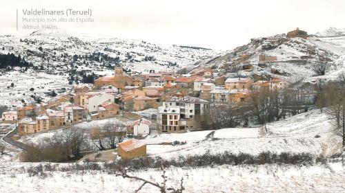 a town covered in snow on a mountain at Apartamento Valdelinares,Casa la roca in Valdelinares