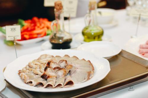 a table with a plate of food on a table at Nobilis Hotel in Lviv