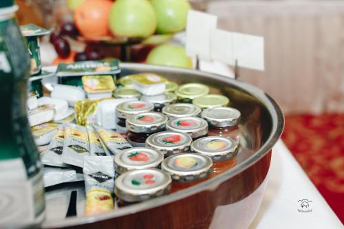 a tray filled with jars of food on a table at Nobilis Hotel in Lviv