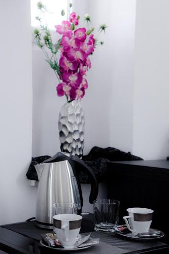 a table with a vase of flowers and a tea kettle at Sleep Split in Split