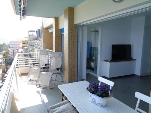 a balcony with a table and chairs and a television at Studio La Florentina in Menton
