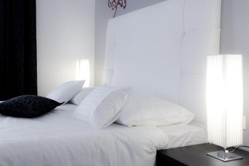 a white bed with white pillows and a table at Sleep Split in Split