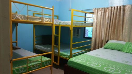 um quarto com 2 beliches e uma cama em Yellow House Vacation Rental em Subic