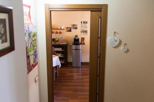 a door leading to a kitchen with a refrigerator at B&B Amici del Colle in San Colombano al Lambro