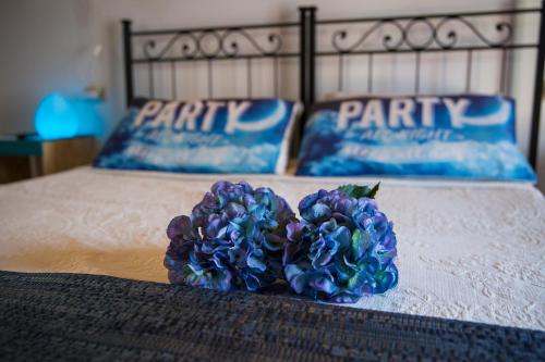 a bouquet of blue flowers sitting on a bed at B&B Amici del Colle in San Colombano al Lambro