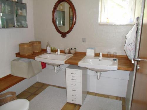 Baño con 2 lavabos y espejo en Natursti Silkeborg Bed & Breakfast, en Them
