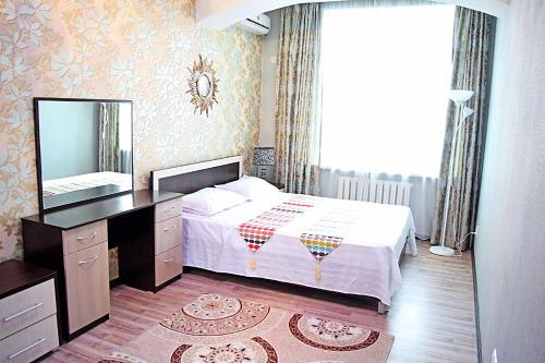 a bedroom with a bed and a dresser and a mirror at Bishkek House Apartament in Bishkek
