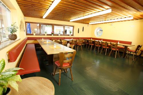 - un restaurant avec des tables et des chaises dans une salle dans l'établissement Outdoor Zentrum Allgäu- Hostel, à Bihlerdorf