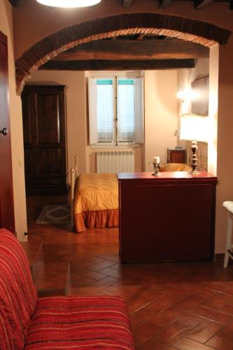 1 dormitorio con 1 cama y lavamanos en una habitación en La Fiera Vecchia Apartments, en Meleto
