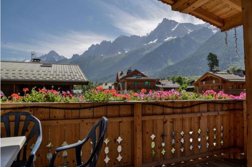 a balcony with a table and chairs and flowers at Le Saint Antoine in Les Houches