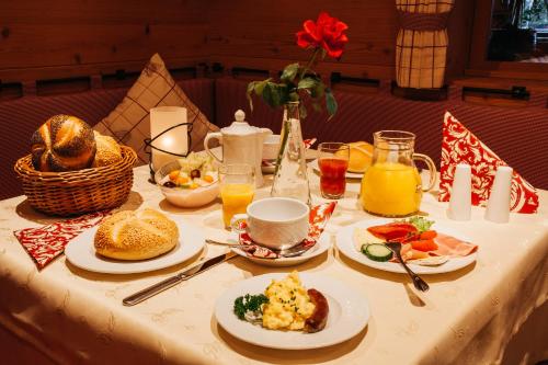 un tavolo con sopra piatti di cibo per la colazione di "Ferienwohnung Anna" - Annehmlichkeiten von 4-Sterne Familien-und Wellnesshotel Viktoria können mitgenutzt werden a Oberstdorf