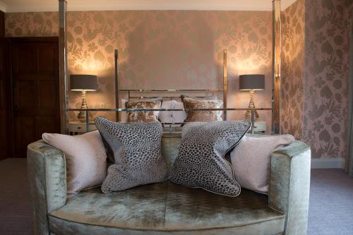 a couch with pillows on it in a room at Hogarths Stone Manor in Kidderminster