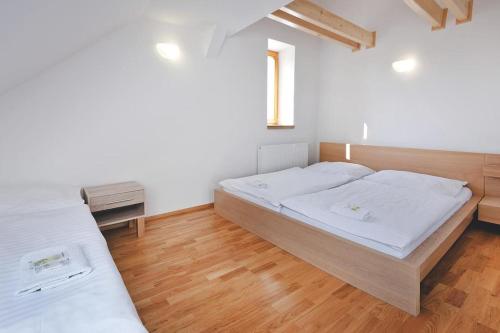 a bedroom with two beds and a wooden floor at Restaurace a Pension Hřebíkárna in Chomutov