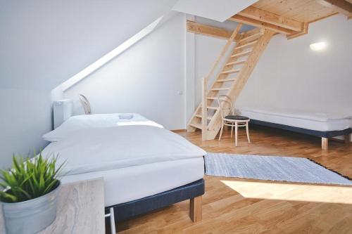 a bedroom with two beds and a stair case at Restaurace a Pension Hřebíkárna in Chomutov