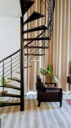 a spiral staircase in a living room with a chair at The Saneer Jaipur in Jaipur