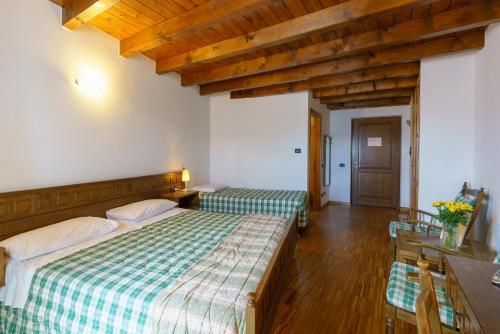 a bedroom with two beds and a wooden ceiling at Agriturismo Giacomino in Gera Lario