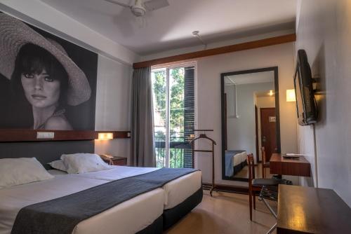 una habitación de hotel con una cama con una foto de una mujer en Hotel do Carmo, en Funchal