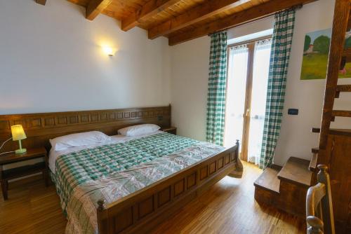 a bedroom with a bed and a large window at Agriturismo Giacomino in Gera Lario