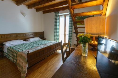a bedroom with a bed and a table in a room at Agriturismo Giacomino in Gera Lario