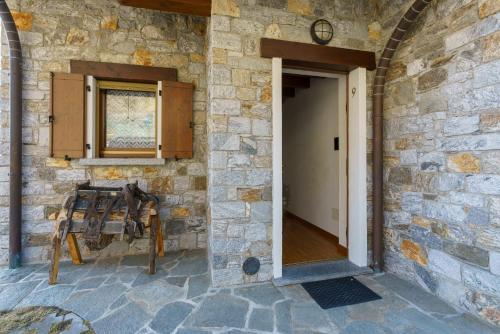 a stone building with a door and a window at Agriturismo Giacomino in Gera Lario