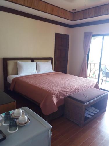 a bedroom with a large bed and a table at Infinity Heights Resort in Siquijor