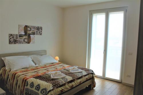 a bedroom with a bed and a large window at Residenza Somma in Sommacampagna