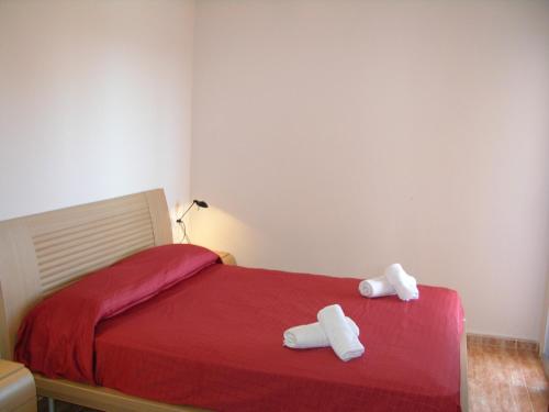 una camera da letto con un letto rosso con due asciugamani di Penthouse Los Miradores del Puerto a La Manga del Mar Menor