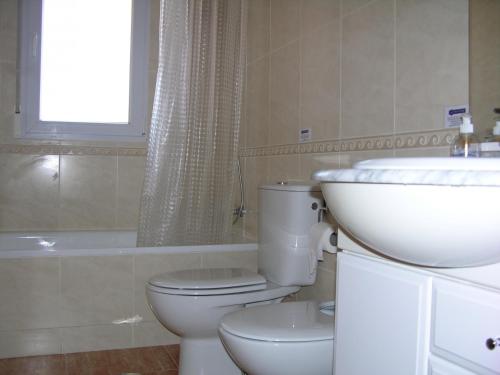 a bathroom with a toilet and a sink and a tub at Penthouse Los Miradores del Puerto in La Manga del Mar Menor