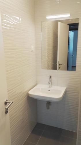 a bathroom with a white sink and a mirror at Bajta na obzidju in Maribor
