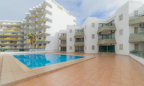 an exterior view of a building with a swimming pool at Algamar by Garvetur in Vilamoura