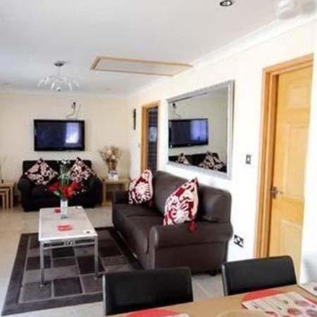 a living room with a couch and a table at Winchfawr Lodge in Merthyr Tydfil