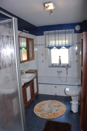 a bathroom with a tub and a sink and a toilet at Reiger Ferienwohnungen in Wackersdorf