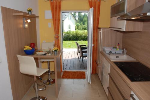 a kitchen with a table and a door to a patio at Reiger Ferienwohnungen in Wackersdorf