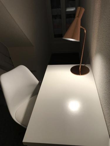 a white table with a lamp on top of it at Le Tronçais in Saint-Bonnet-Tronçais