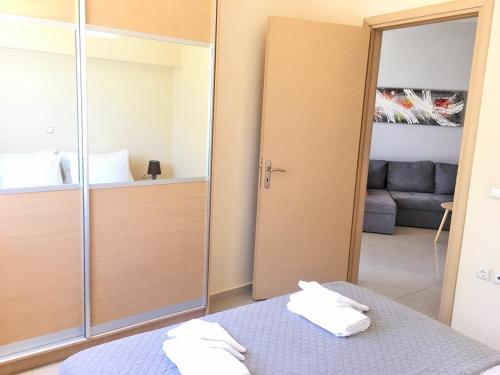 Agios OnoufriosにあるPretty Apartmentのベッド1台とガラスのスライドドアが備わる客室です。