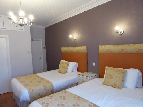 a hotel room with two beds and a chandelier at The Berwick - Over 40's Only in Blackpool