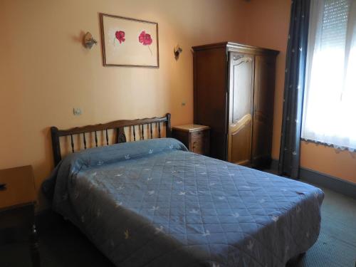 a bedroom with a bed with a blue comforter at Hotel de la gare in Cosne-Cours-sur-Loire