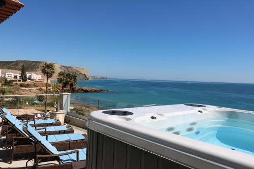 a hot tub on a balcony overlooking the ocean at Casa do Mar - Luxurious Villa with Swim Spa & sea view in Luz