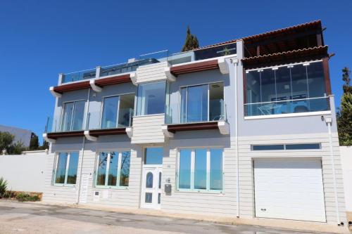a white house with a lot of windows at Casa do Mar - Luxurious Villa with Swim Spa & sea view in Luz