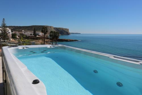 a swimming pool with a view of the ocean at Casa do Mar in Luz