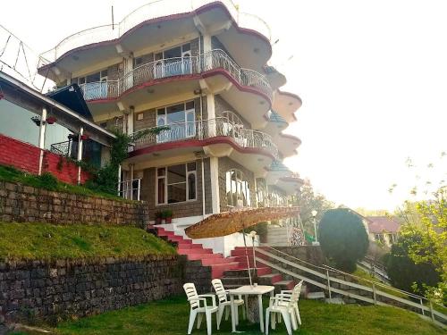 a building with a table and chairs in front of it at Hotel Victoriya Palace,Mcleod Ganj in McLeod Ganj