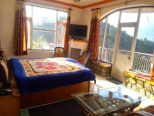 a bedroom with a bed and a balcony with windows at Hotel Victoriya Palace,Mcleod Ganj in McLeod Ganj